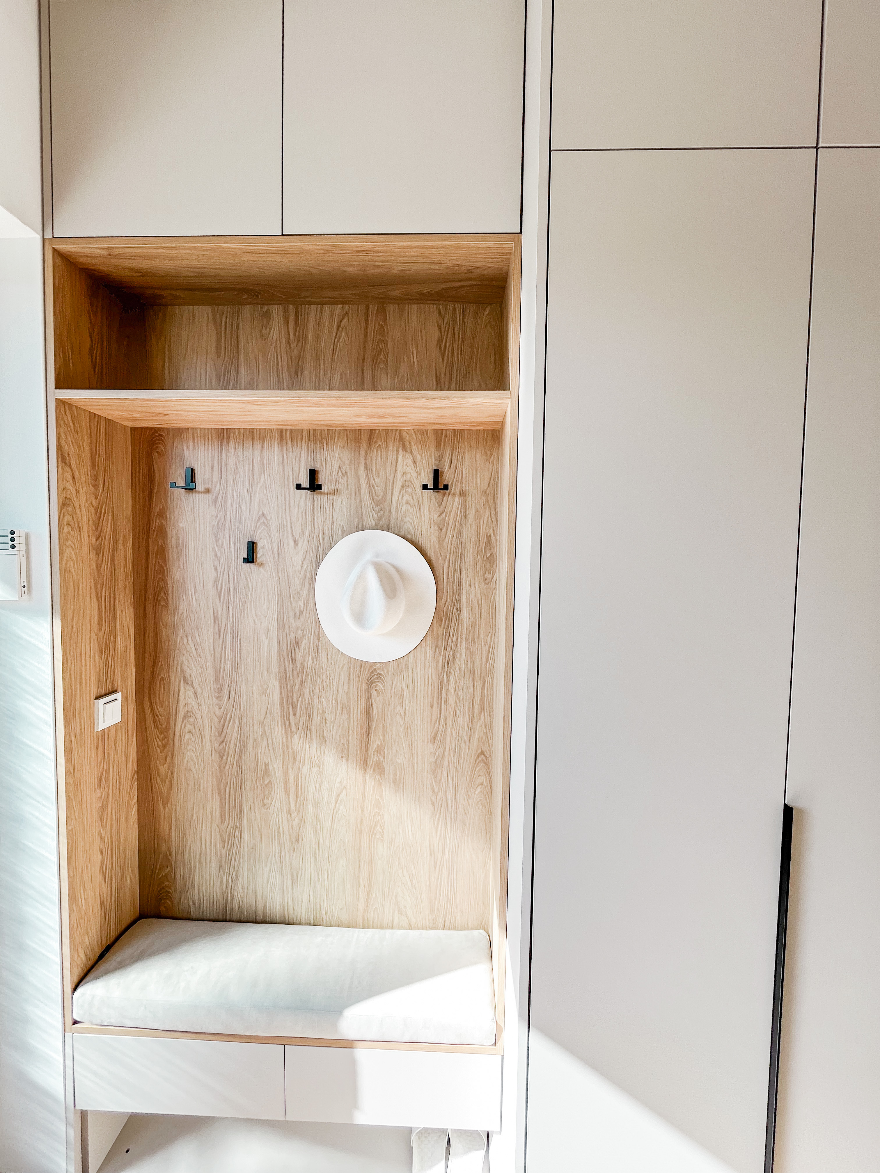 světle béžové polstry do stěny v předsíni